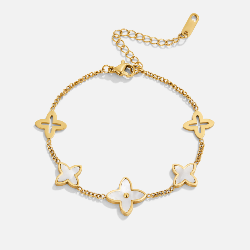 White Blossom Petal Bracelet, flat lay of gold bracelet with white shell and open clover charms