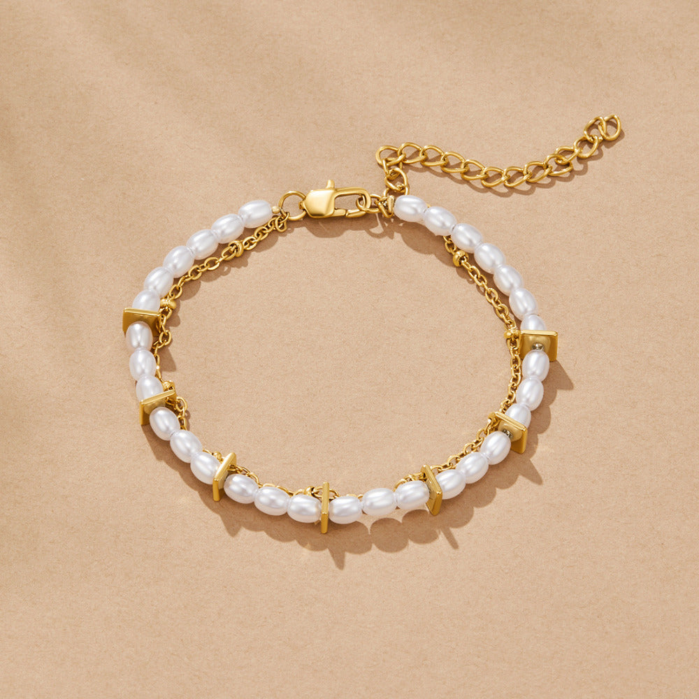 Aria Layered Pearl Bracelet, laid flat on sand-coloured paper, pearls and gold chain in a loop