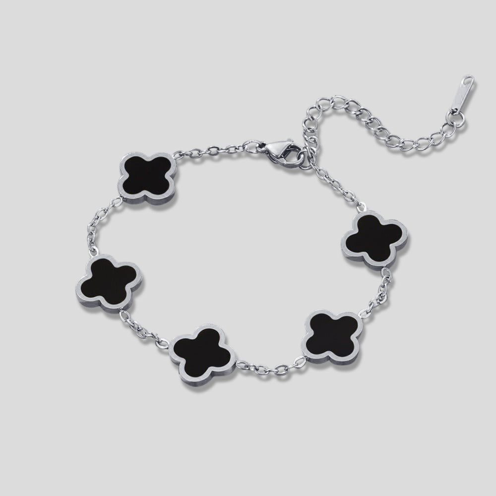 Silver Black Clover Bracelet, flat lay of a bracelet with five black clover motifs and silver links