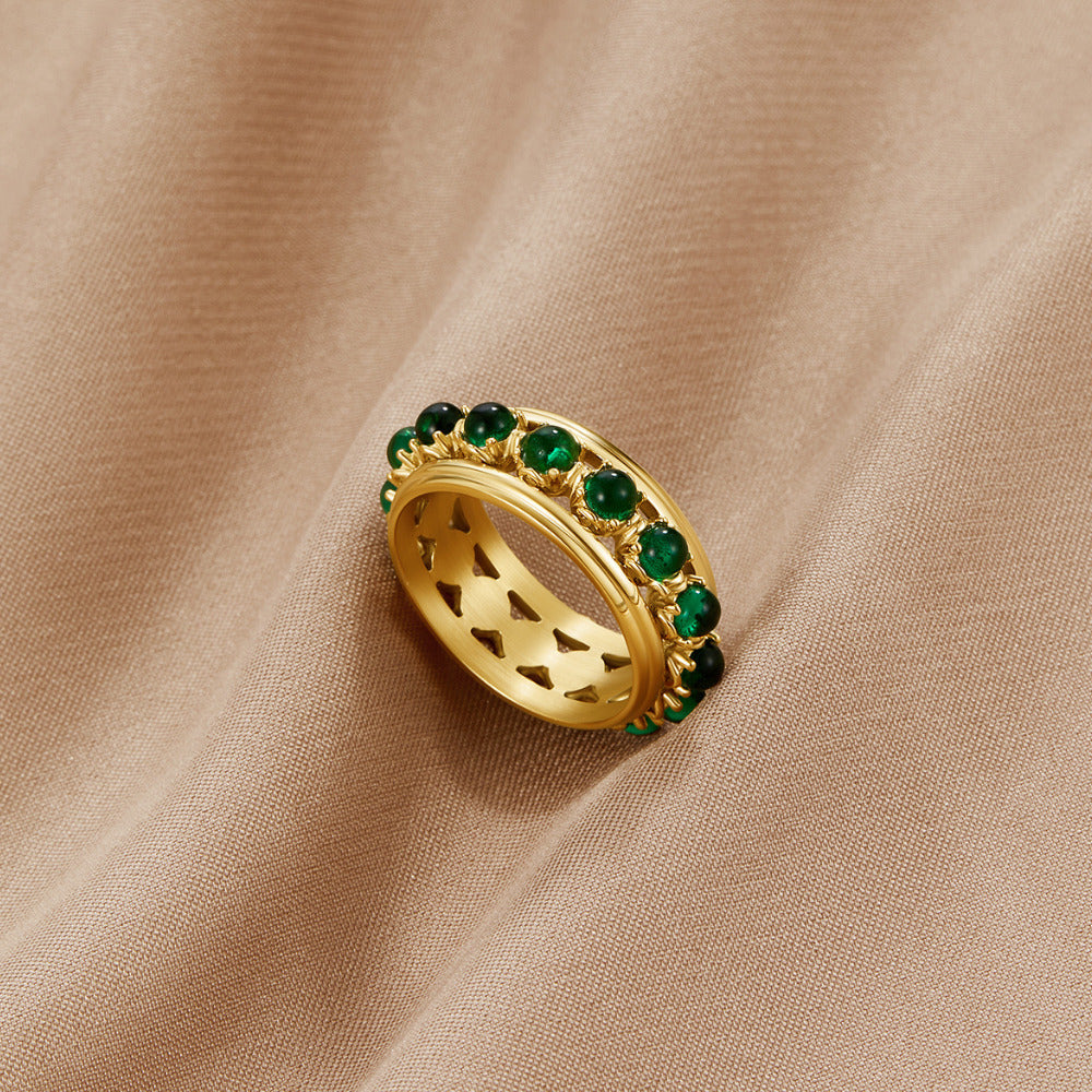 Emerald Stone Crystal Ring, ring resting on beige fabric, green stones and gold band