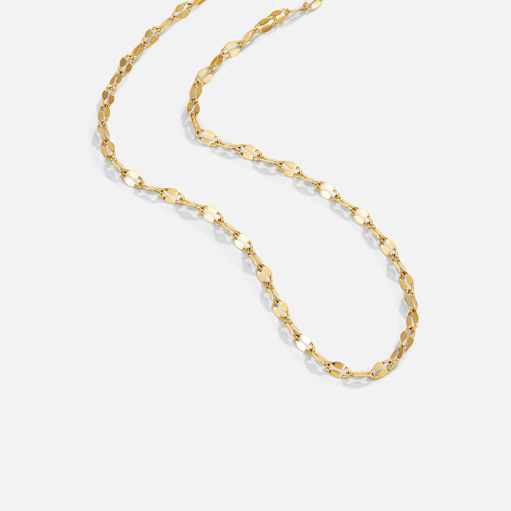 Leila Gold Chain Necklace, gold chain laid flat in a loose curve on light grey