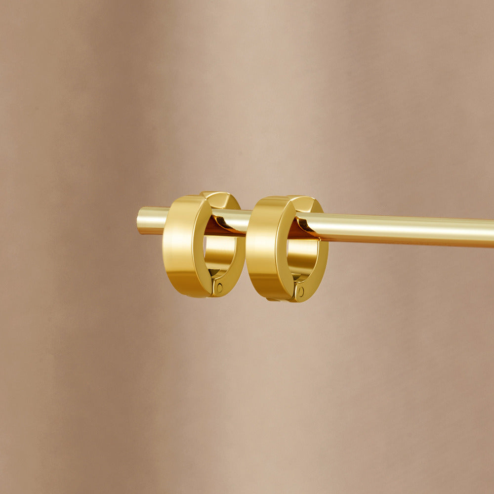 Millie Gold Earring Cuff, two gold hoop earrings hung on a gold rod against a beige backdrop