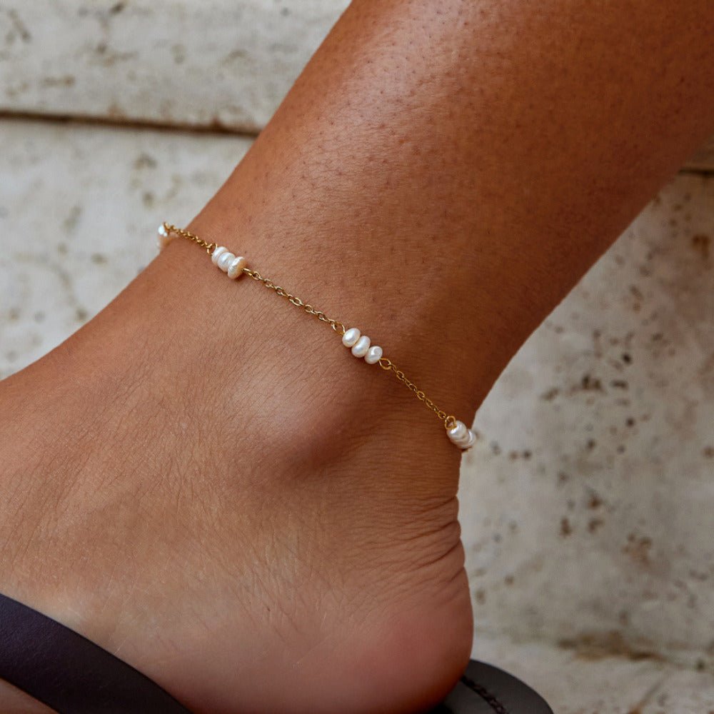 Alena Pearl Anklet, worn on an ankle with a dark sandal, small pearls on gold chain