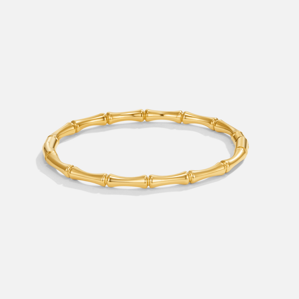 Ara Golden Bamboo Bangle, gold bamboo-segment bangle lying flat on a white background
