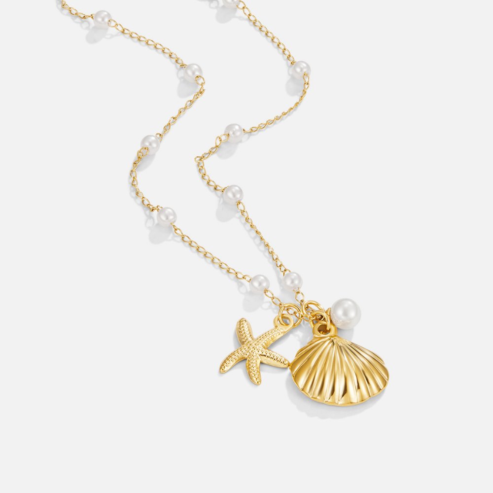 Aria Shell Charm Necklace, gold chain with pearls, starfish and ribbed shell charms on white