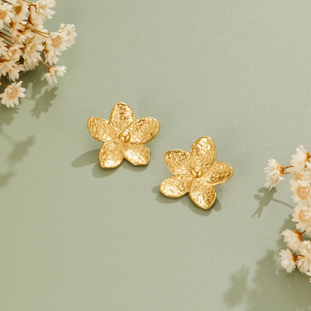 Blooming Gold Flower Earrings, two hammered gold flower earrings on sage green surface, dried