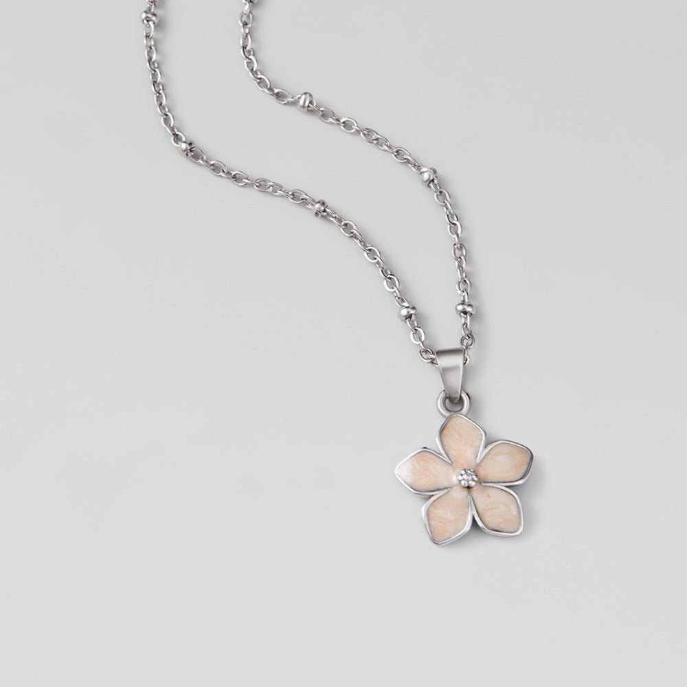 Blush Pink Sakura Bloom Silver Necklace, laid flat on grey, pale pink five-petal flower