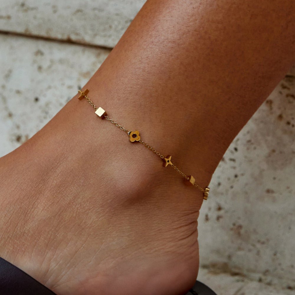 Charlie Gold Anklet, worn on an ankle with small gold charms along the chain