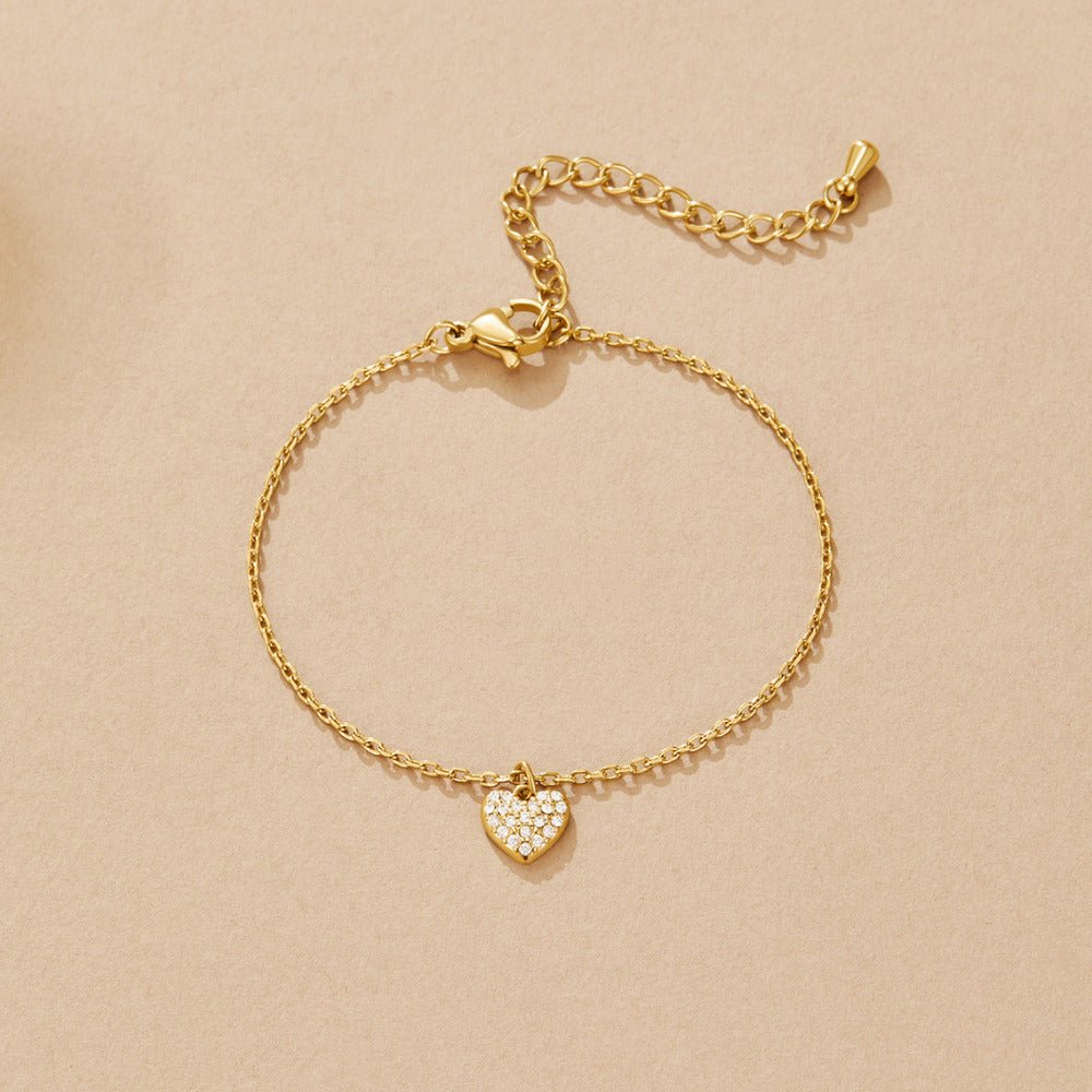 'Crazy in Love' Heart Bracelet, flat lay on beige, gold chain with pavé heart charm