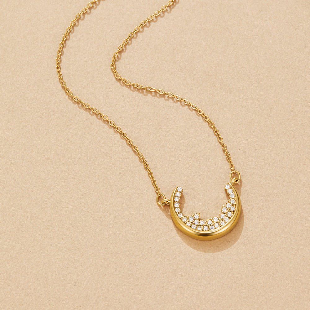 Crescent Moon Pendant Necklace, laid flat on a beige surface, gold chain with crescent pendant