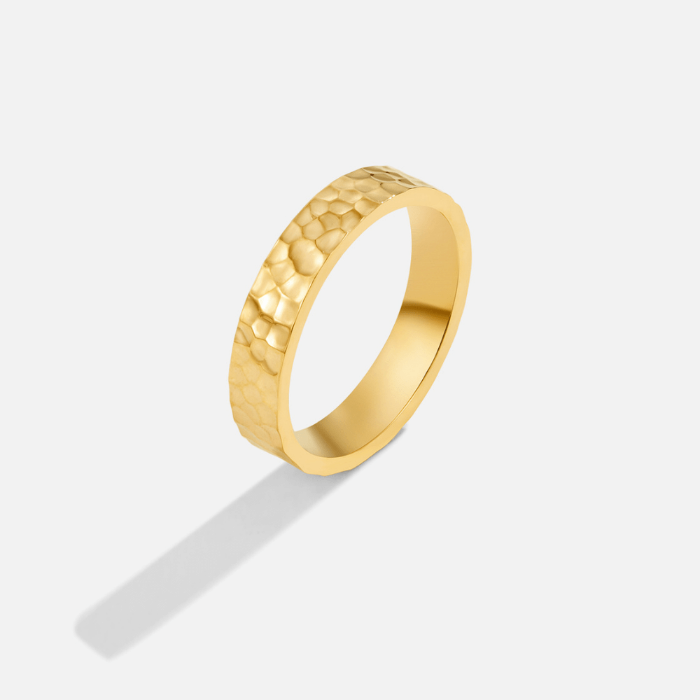 Dorcas Hammered Gold Ring, gold band standing upright on white, hammered texture on outer face