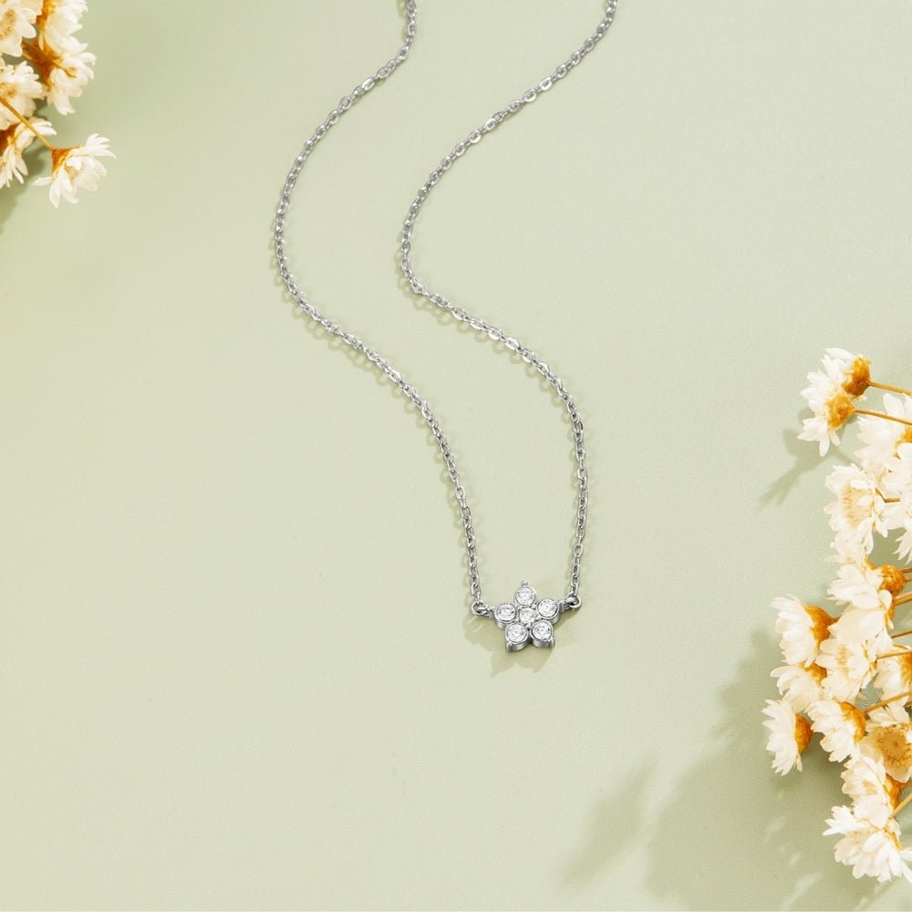 Elara Crystal Bloom Silver Necklace, laid flat on sage green with dried white flowers, flower