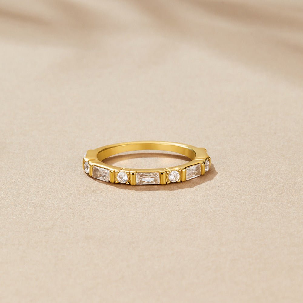 Emily Crystal Baguette Ring, gold ring with alternating baguette and round stones, on beige