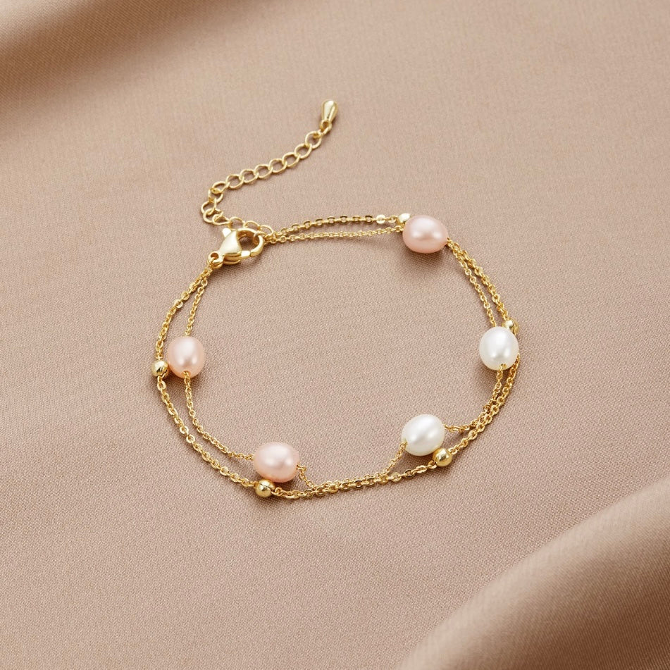 Freshwater Pearl Layered Bracelet, laid flat on beige satin, pink and white pearls on gold