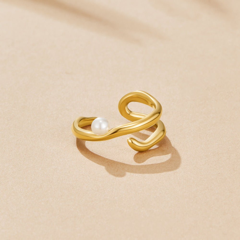 Geometric Gold & Pearl Ring, open gold ring with a small white pearl on a beige surface