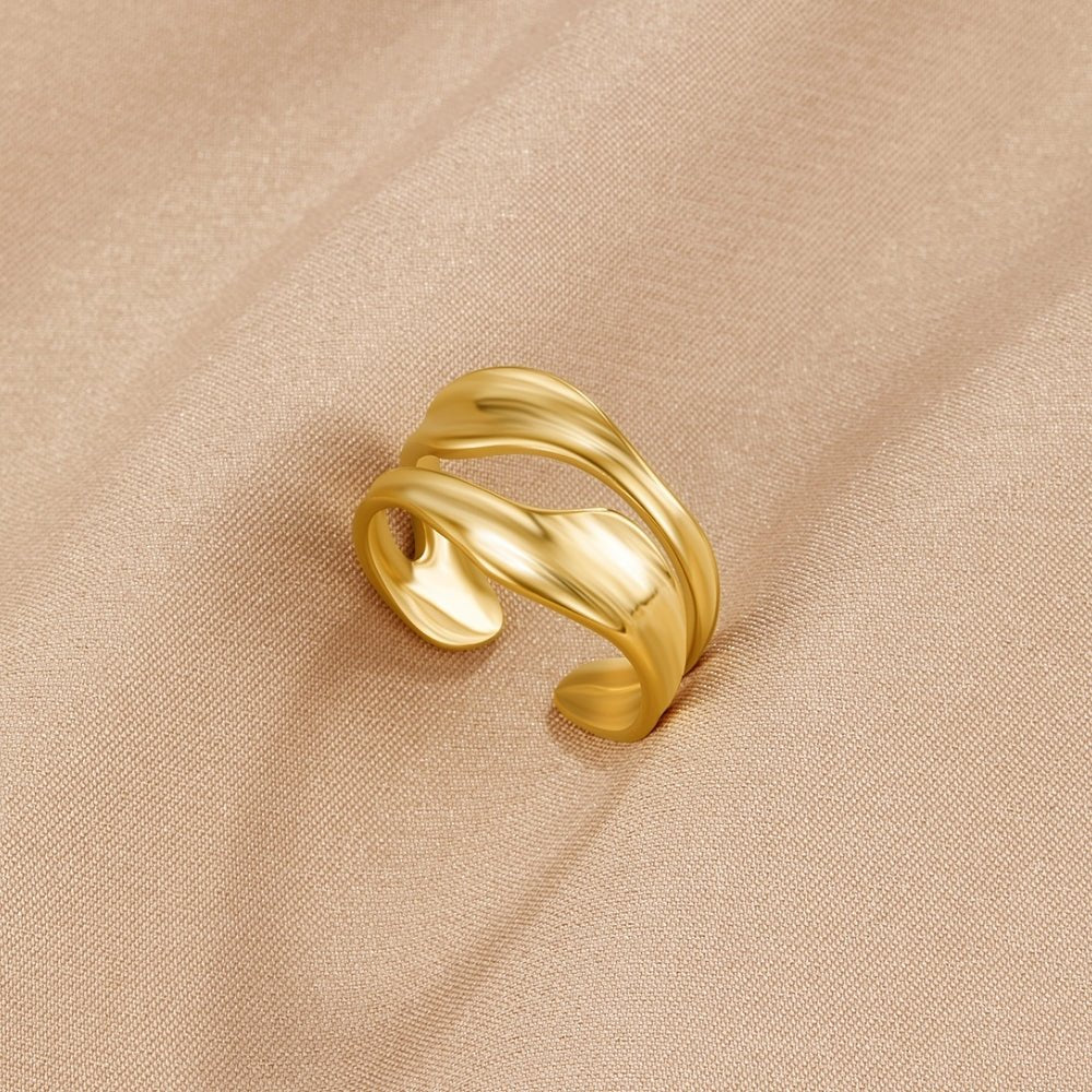 Gold Penelope Ring, gold ring with wavy, open band on beige fabric