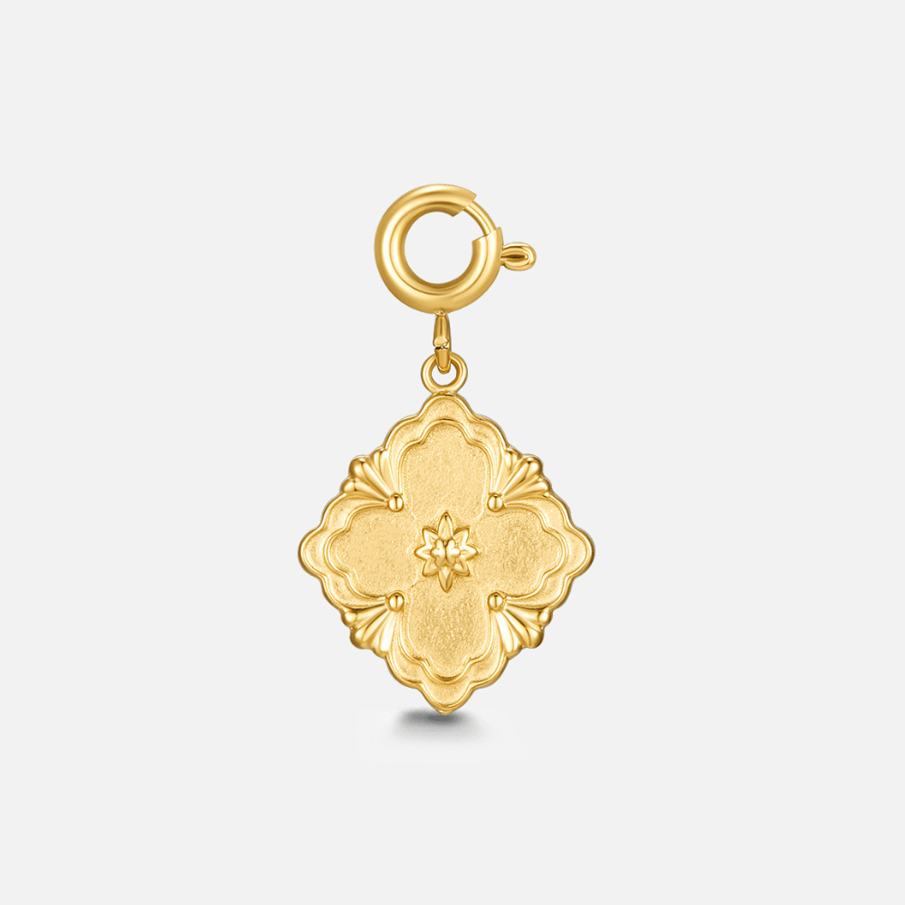 Golden Clover Leaf Charm, gold charm with a spring clasp, on a plain background