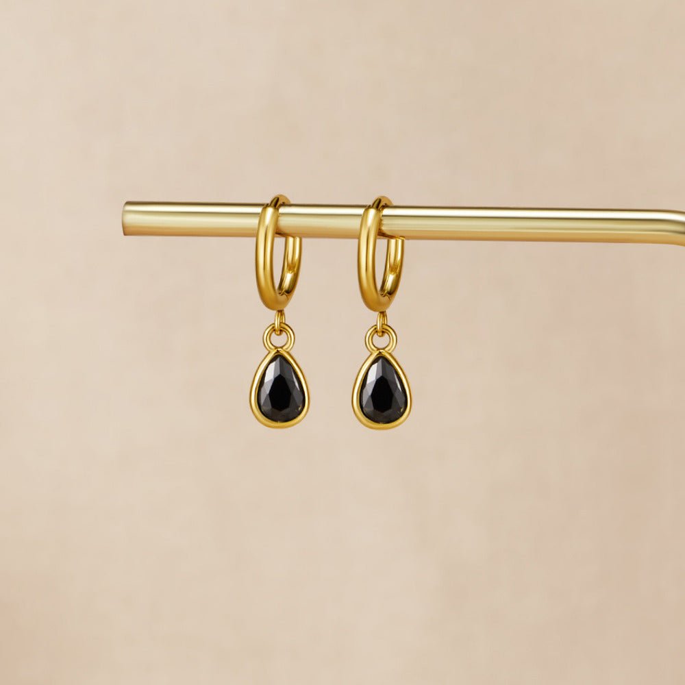 Golden Midnight Teardrop Earrings, hanging from a gold bar, black teardrop stones in gold