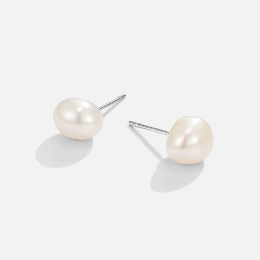 Ina Pearl Stud Earrings, pair of pearl studs lying flat on white, with silver posts