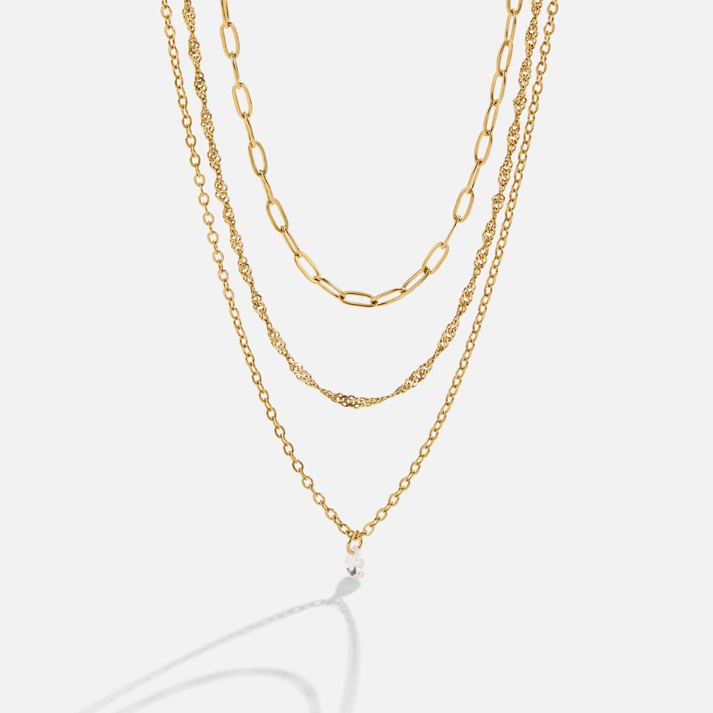 Jana Triple Chain Necklace, three gold chains layered on a plain white background, with a
