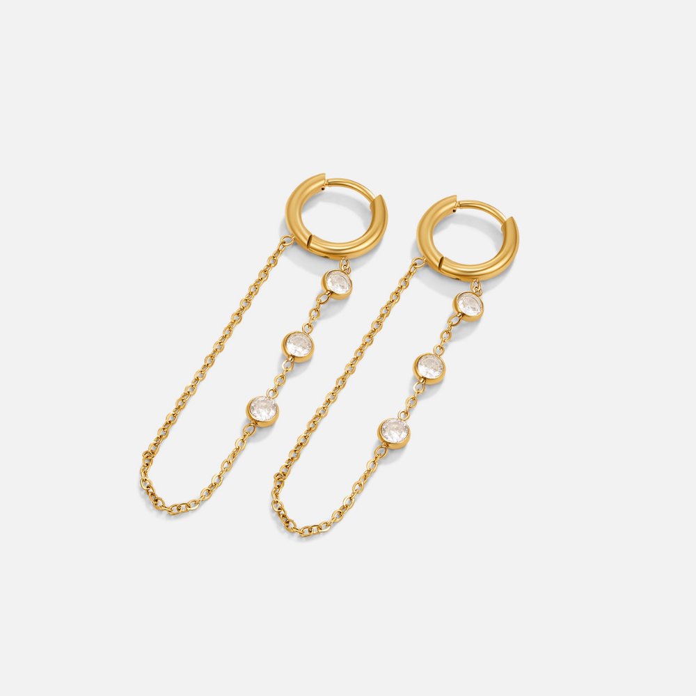 Kira Crystal Drop Hoop Earrings, pair of gold hoops with chains and crystals, flat on white