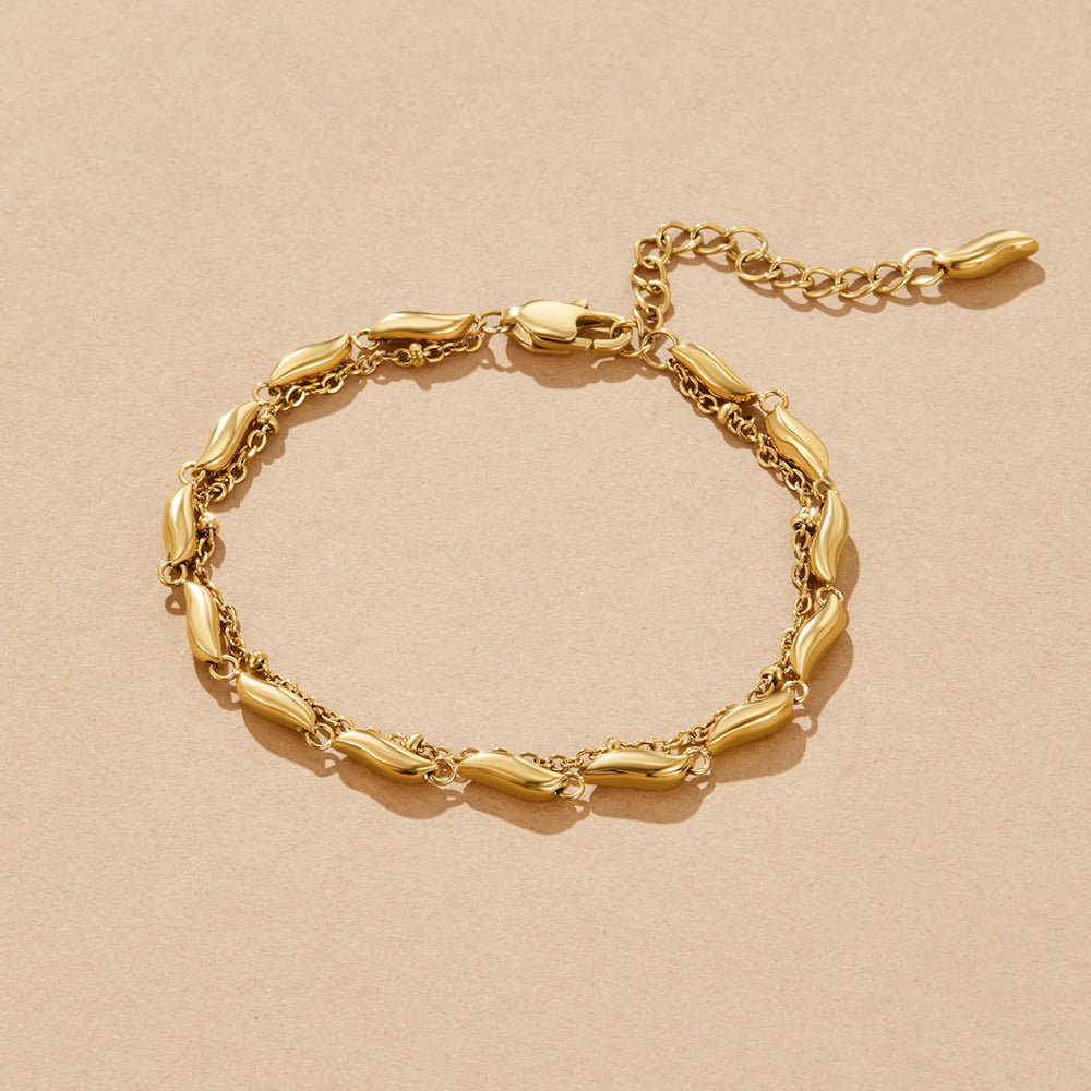 Layered Gold Wave Bracelet, laid flat on beige paper, gold bracelet with extender chain