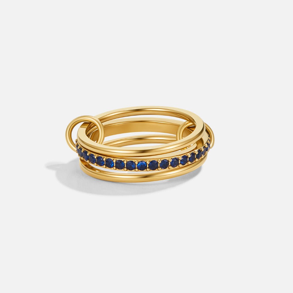 Layered Kaili Blue Crystal Ring, stacked gold rings with a row of blue stones, on white
