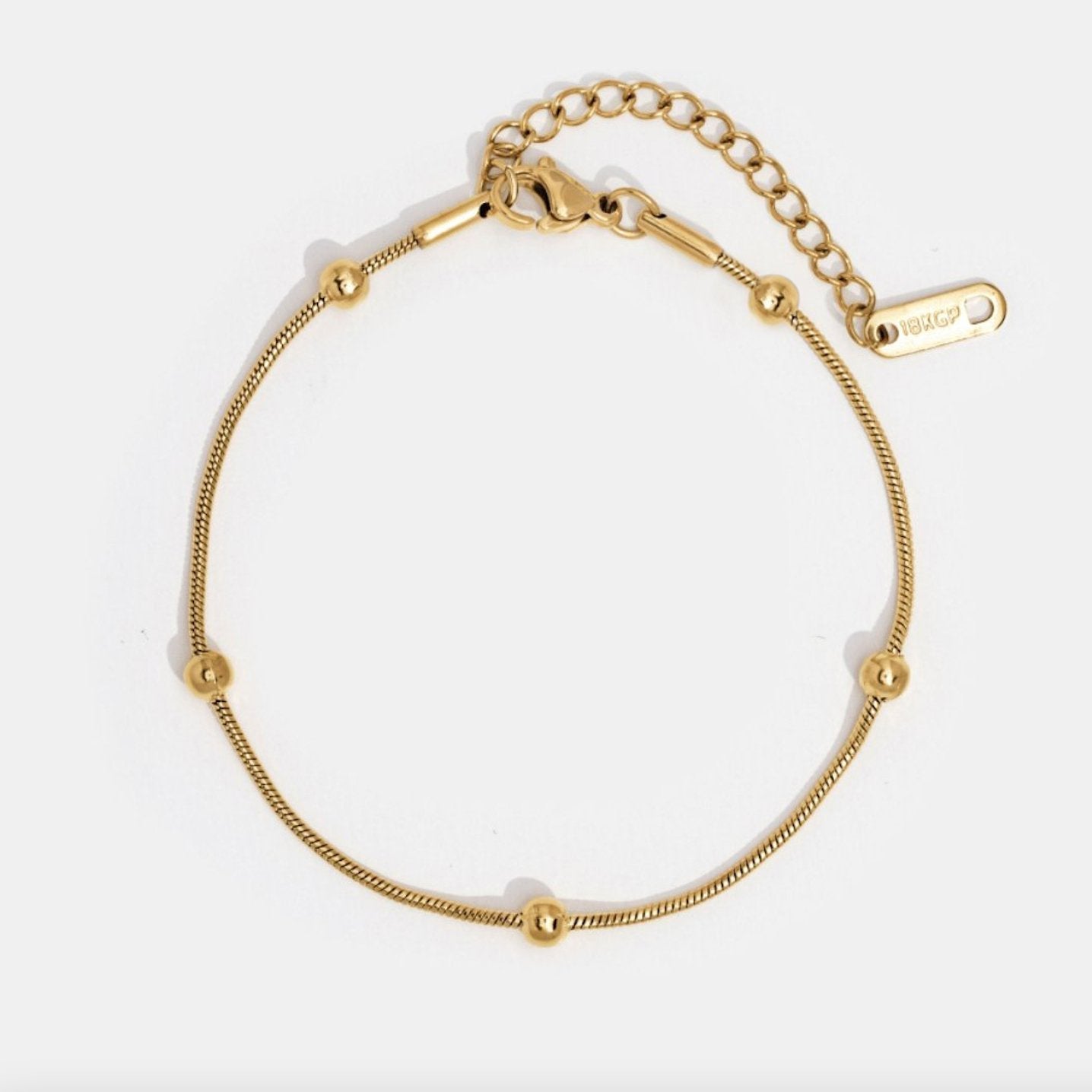 Luna Gold Bead Bracelet, flat lay of a gold chain bracelet with five round beads and an