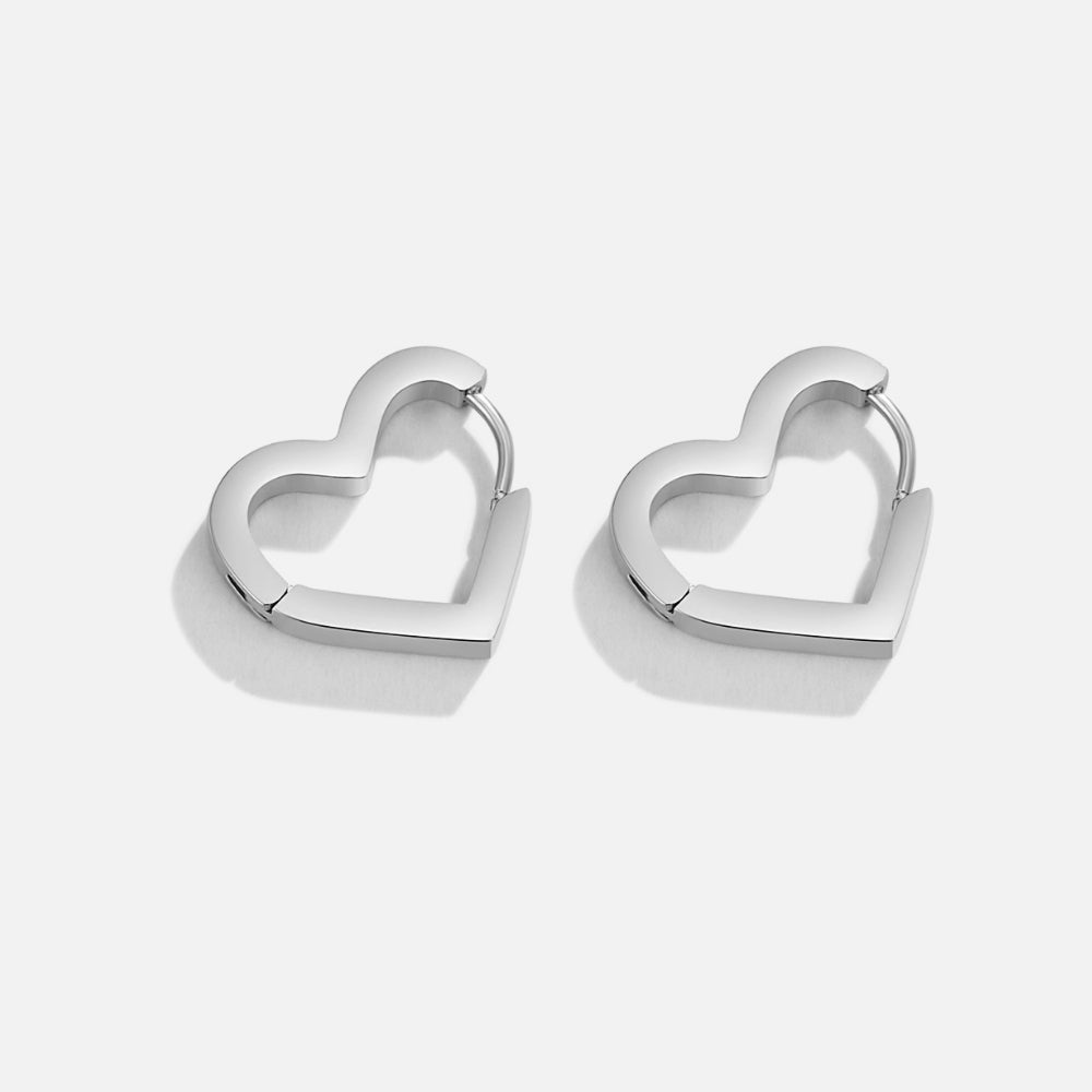 Mary Heart Silver Hoop Earrings, pair of polished silver heart-shaped hoops on a plain background
