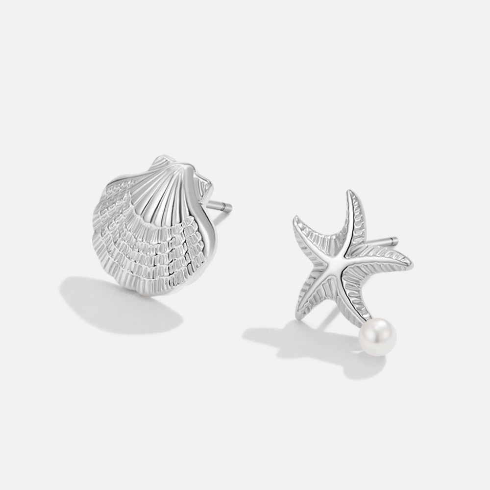 Naia Shell & Starfish Silver Earrings, pair of mismatched silver earrings on a plain
