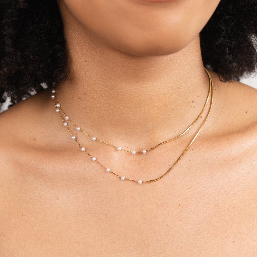 Pearl & Gold Long Chain Necklace, worn on a neck layered with a pearl chain and gold snake chain