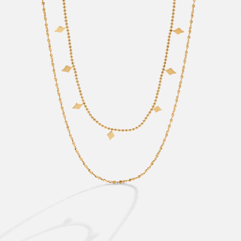 Phoenix Layered Necklace, two gold layered chains, one beaded with diamond-shaped charms, on white
