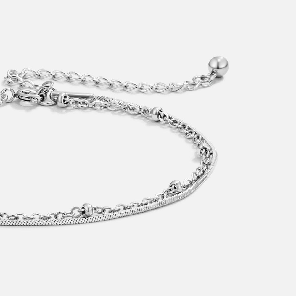 Pia Silver Layered Bracelet, close-up of layered silver chains with beads and a clasp on white