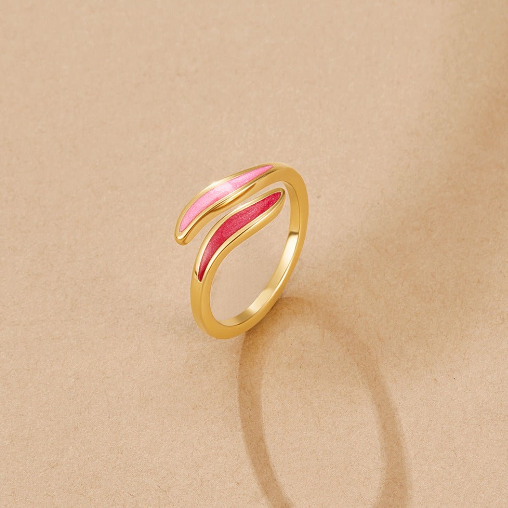 Pink Blush Wrap Ring, gold open wrap ring with pink and red enamel leaves on beige surface