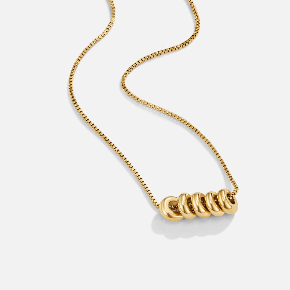 'Rings of Happiness' Gold Necklace, gold box-chain necklace laid out with five linked rings