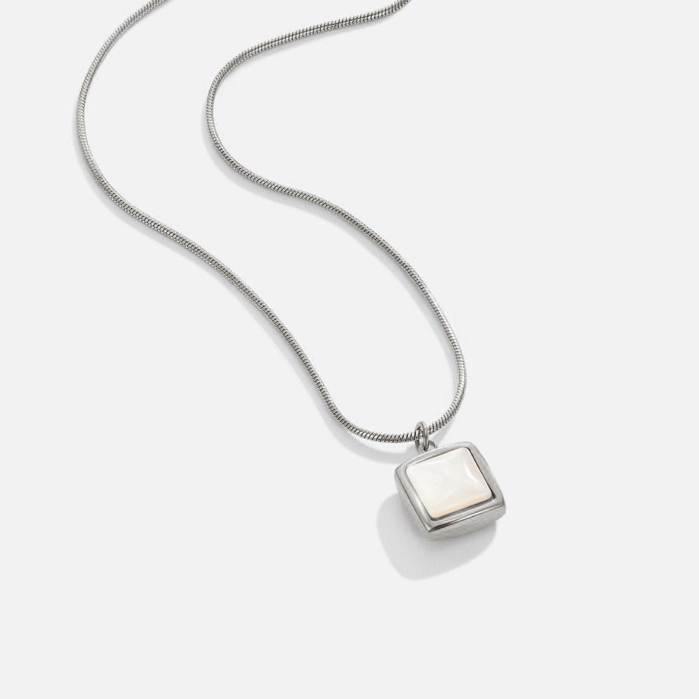 Riva Moonstone Pendant Necklace, laid flat on white, silver chain with square white pendant