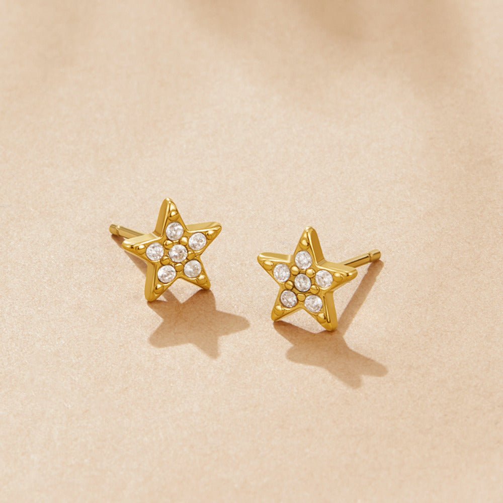 'Shooting Star' Stud Earrings, pair of star studs lying on a beige surface, pavΓ© stones in the centre