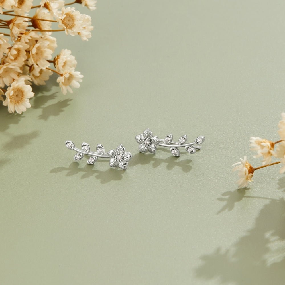 Silver Crystal Vine Earrings, a pair of silver vine earrings lying on sage green with dried