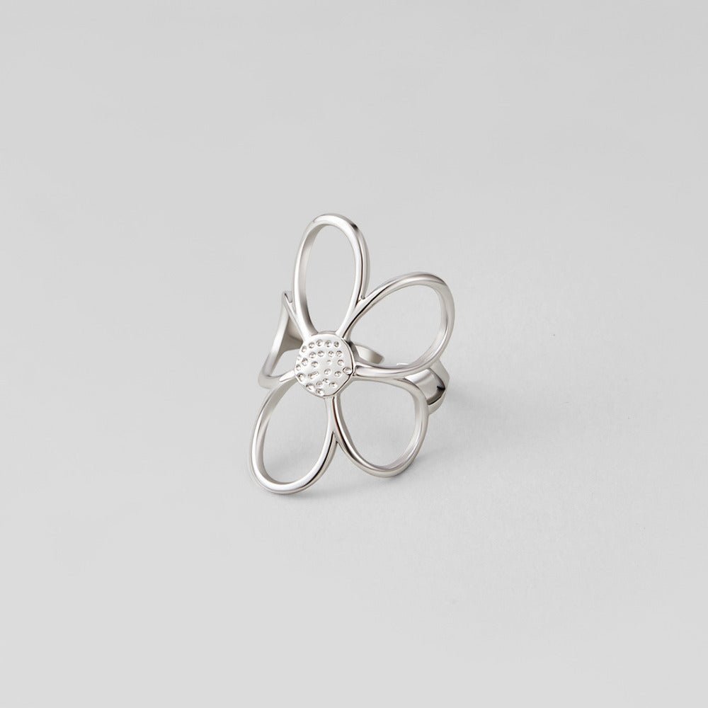 Silver Daisy Flower Ring, standing silver ring with open flower petals and a dotted centre on grey
