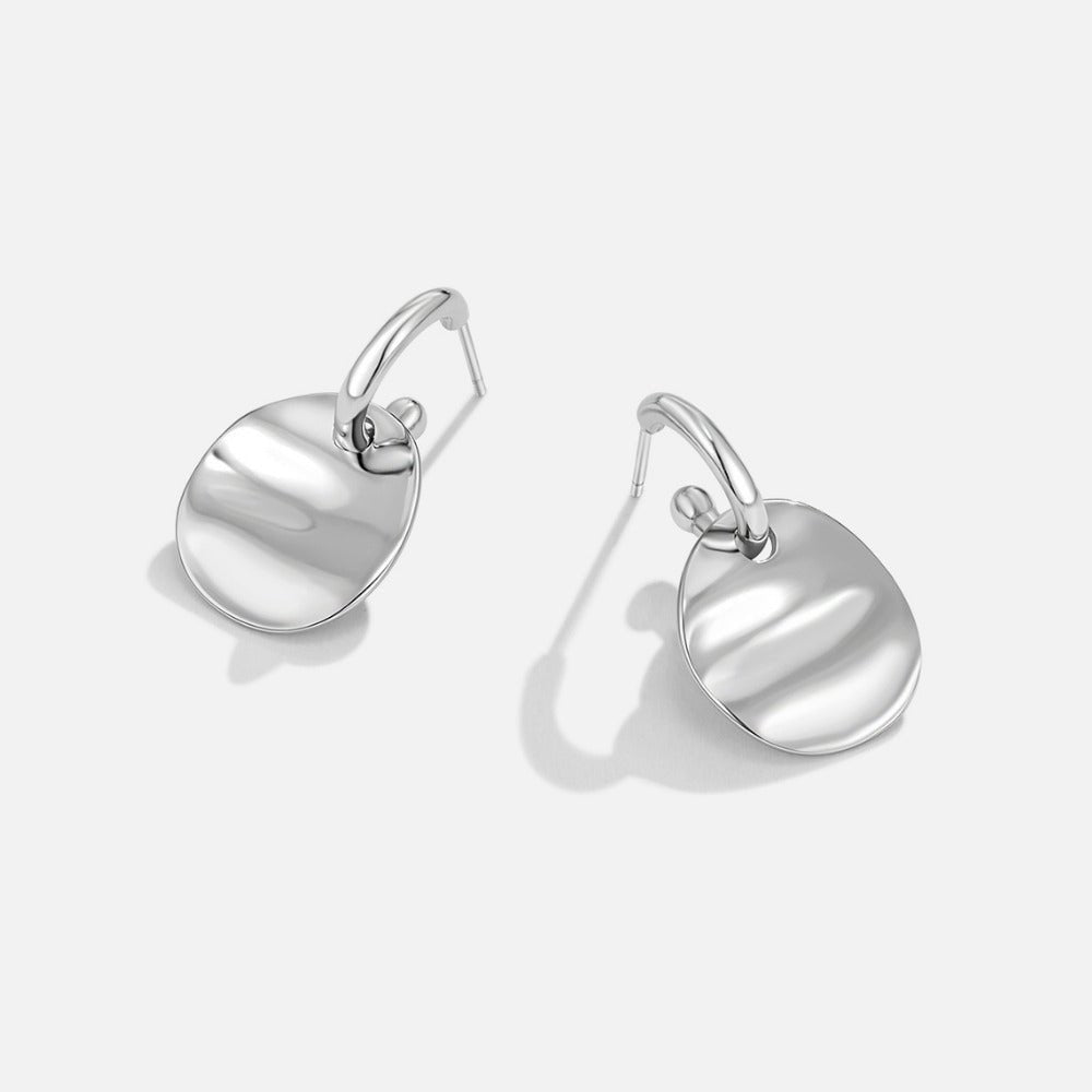 Silver Disc Drop Earrings, pair of polished silver earrings on a plain light background