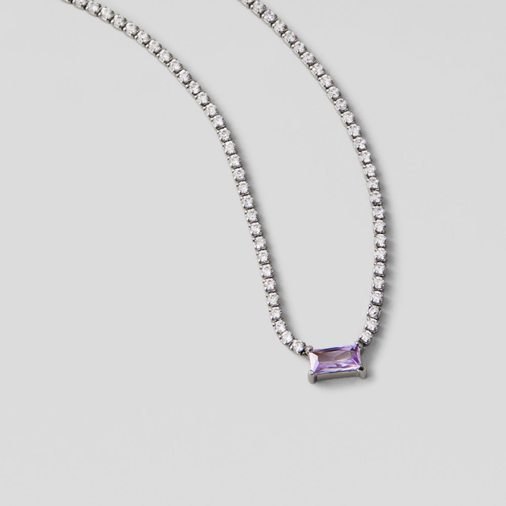 Silver Luxe Crystal Necklace, laid flat on grey, with a purple baguette stone pendant