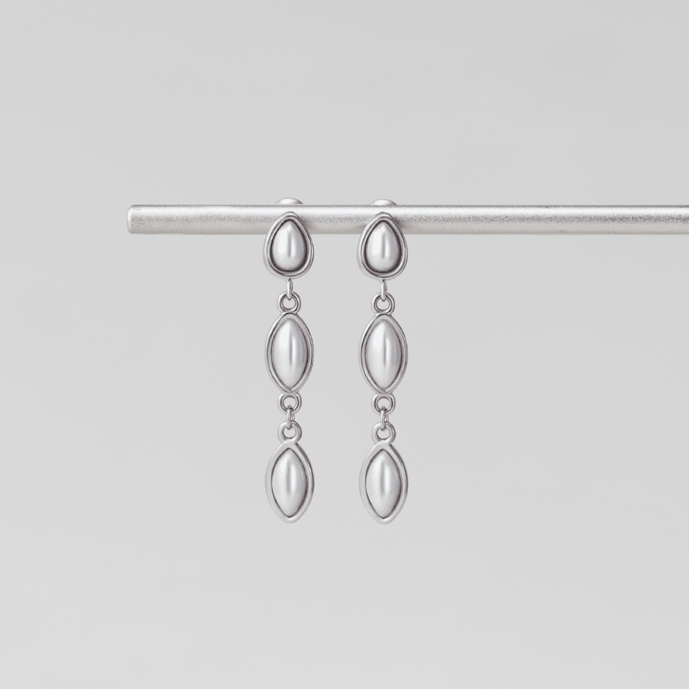 Silver Serena Pearl Drop Earrings, pair hanging from a silver bar on a grey background