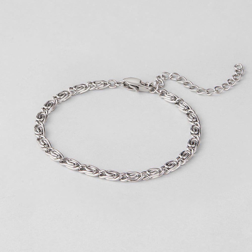Silver Swirl Link Chain Bracelet, laid flat on grey, with clasp and extender chain visible