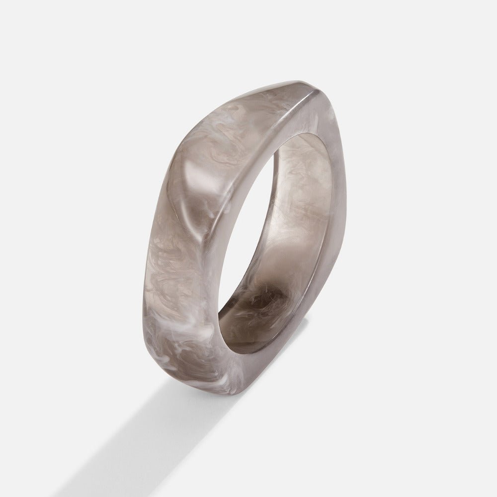 Smoked Grey Swirl Bangle, standing alone on white, angled, grey marbled resin with a squared profile
