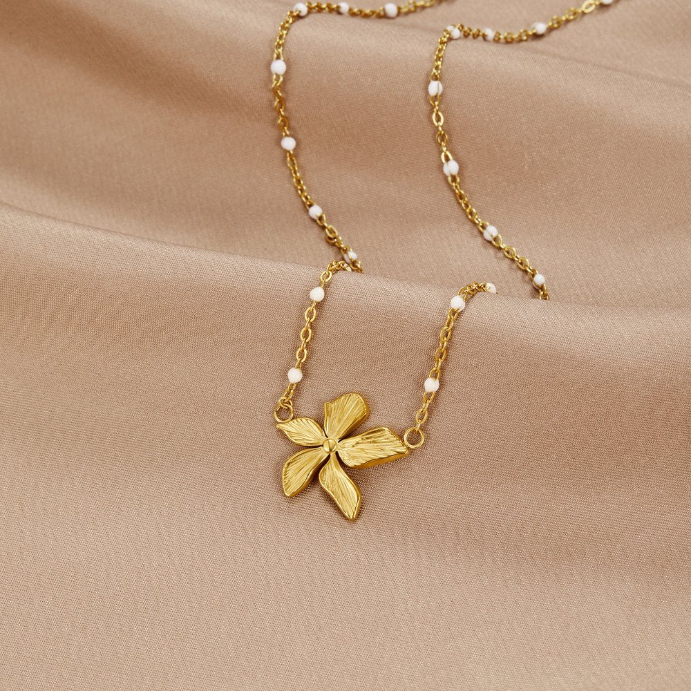‘Spring Bloom’ Bead Necklace, laid flat on beige satin, gold flower pendant on beaded chain