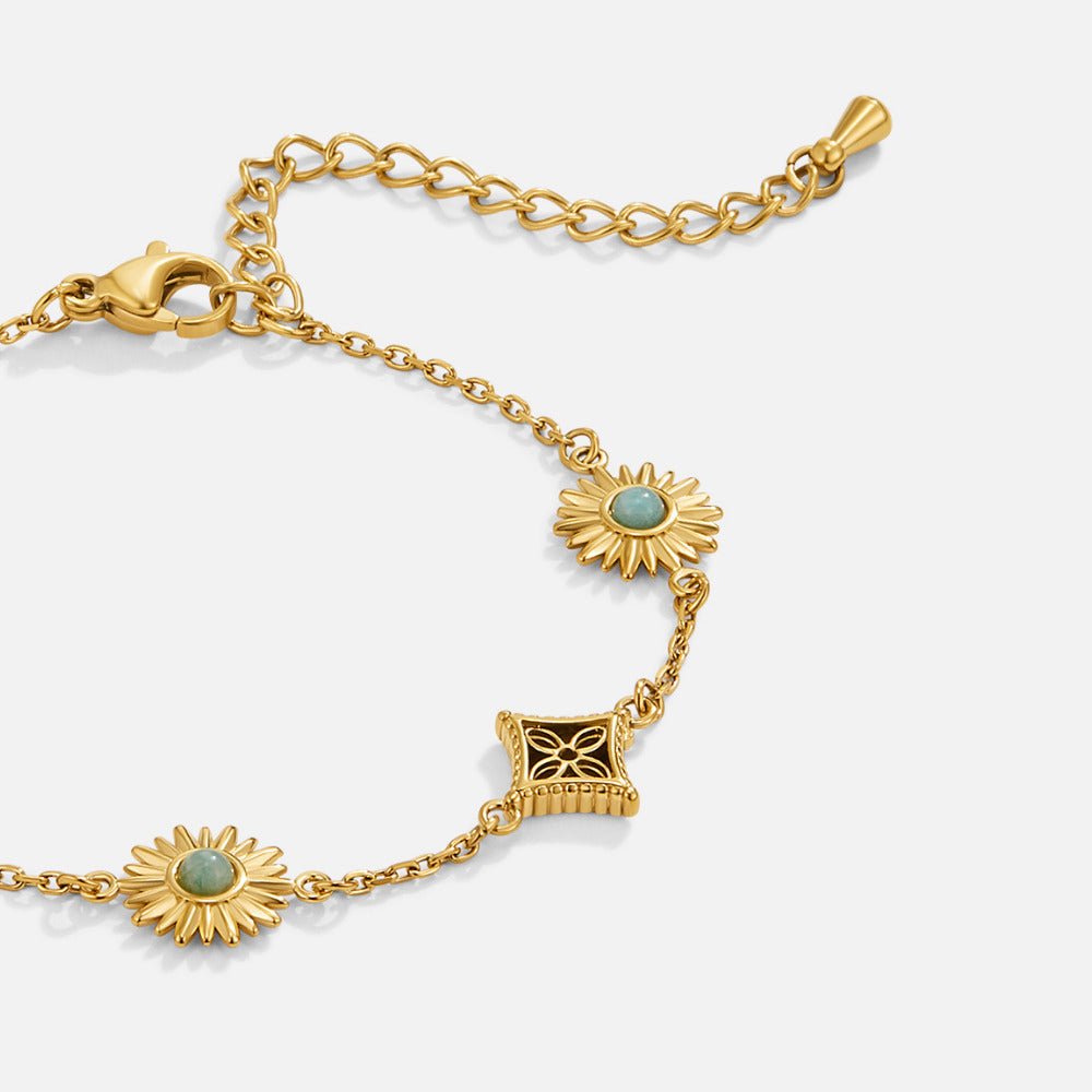 'Sunkissed' Turquoise Bracelet, close-up of gold chain with sun motifs and green stones, flat