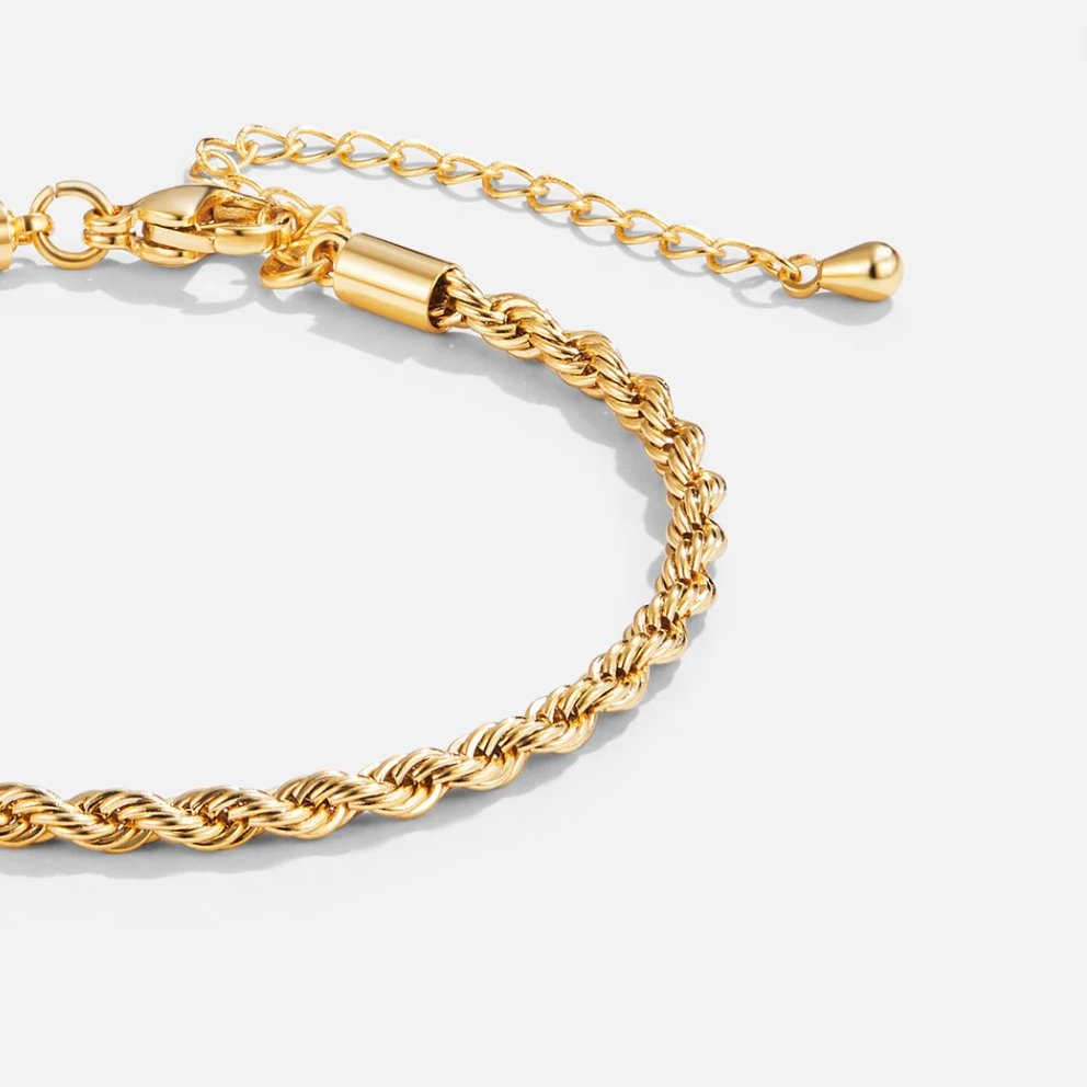 Twisted 18K Gold Bracelet, close-up of a gold rope-twist bracelet on a light grey background