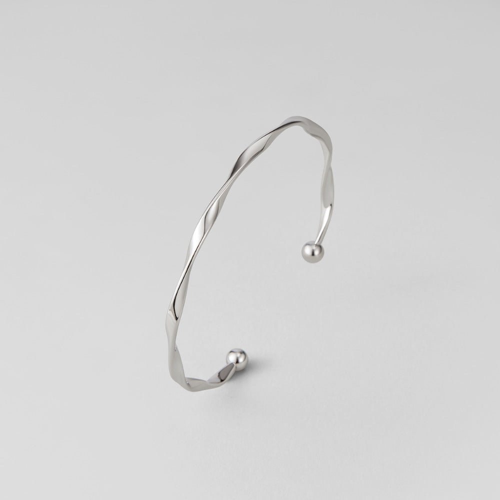 Twisted Imari Silver Bangle, open cuff bangle on plain light grey background, ball ends