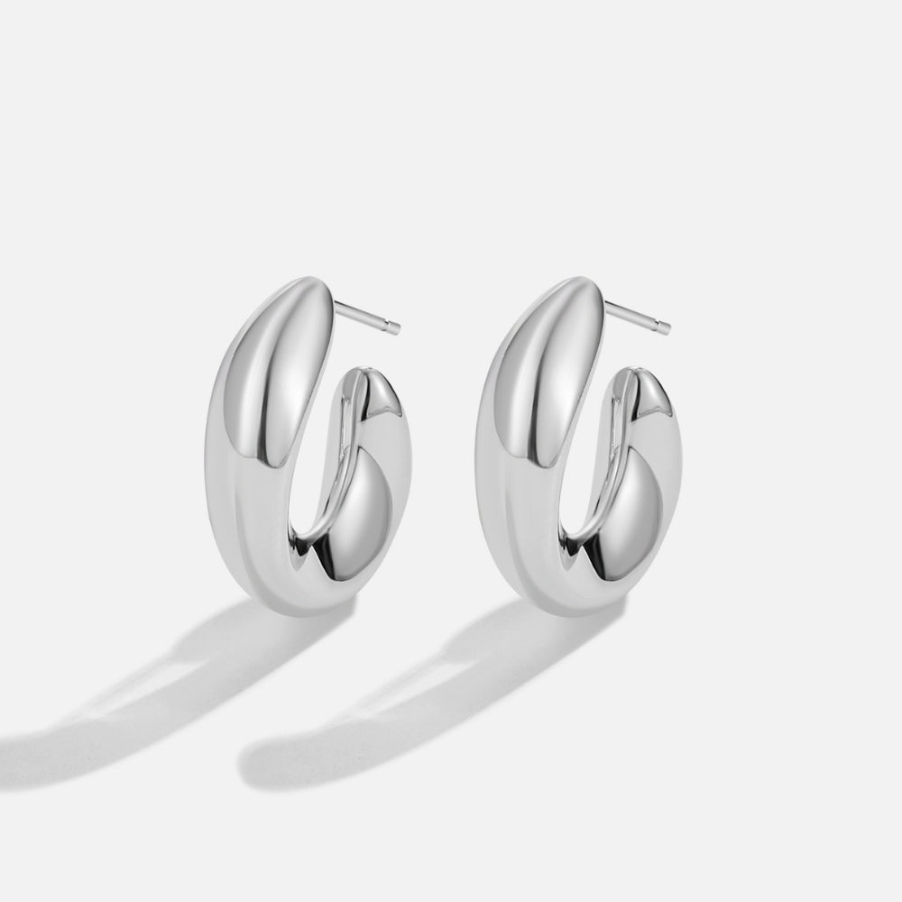 Twisted Sarah Silver Hoop Earrings, pair of polished silver hoop earrings on a plain background