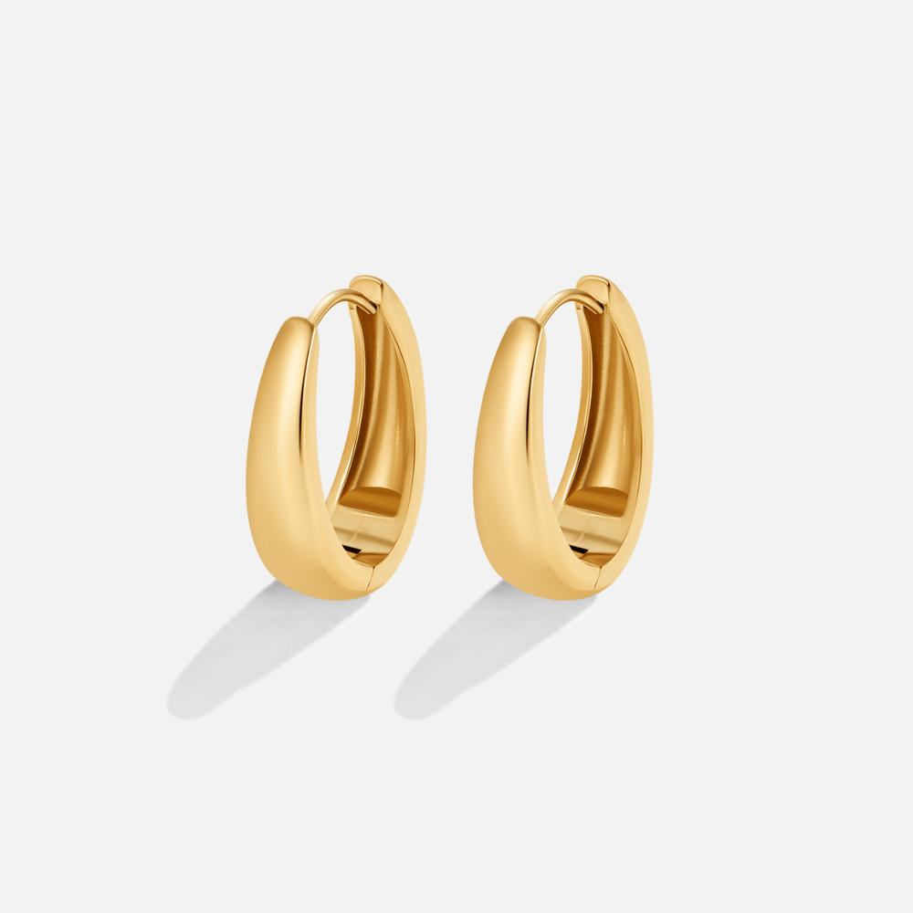 Valentina Gold Hoop Earrings, pair of polished gold oval hoop earrings on a plain light background